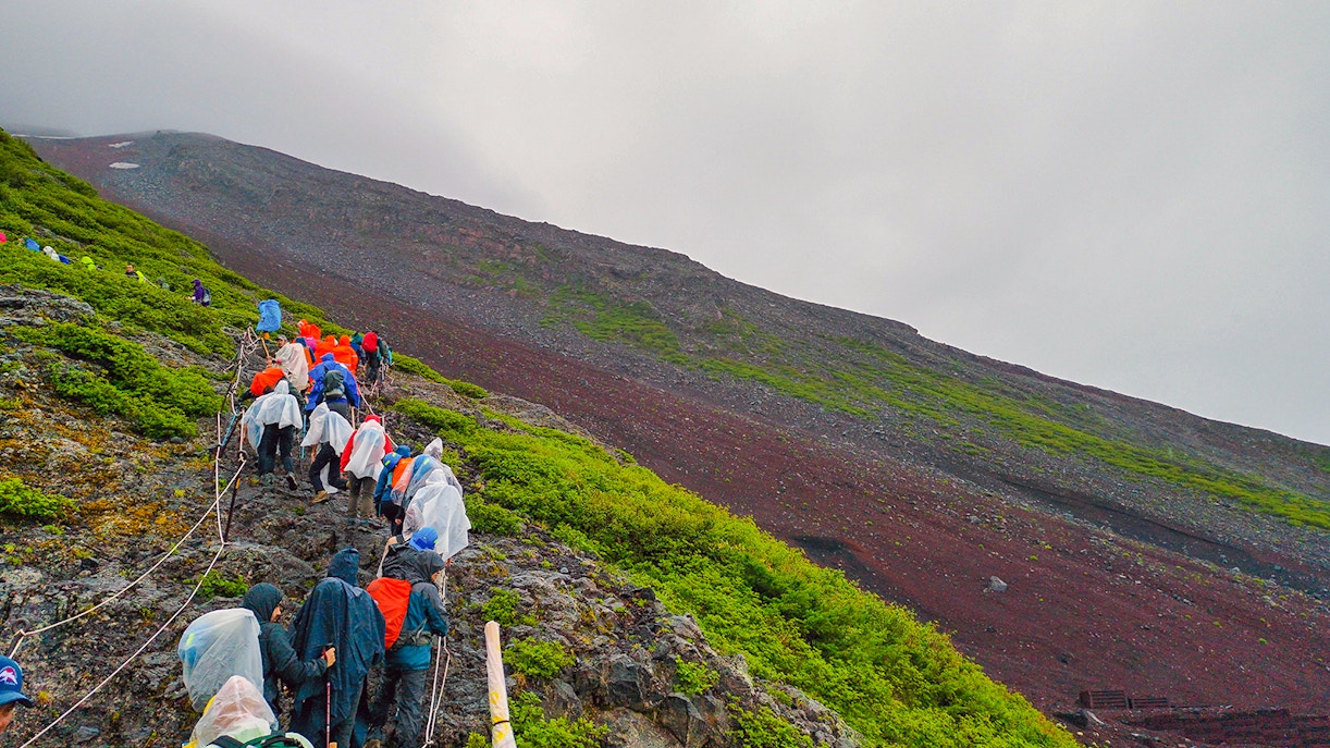 Hikers climbing Mt. Fuji in the rain