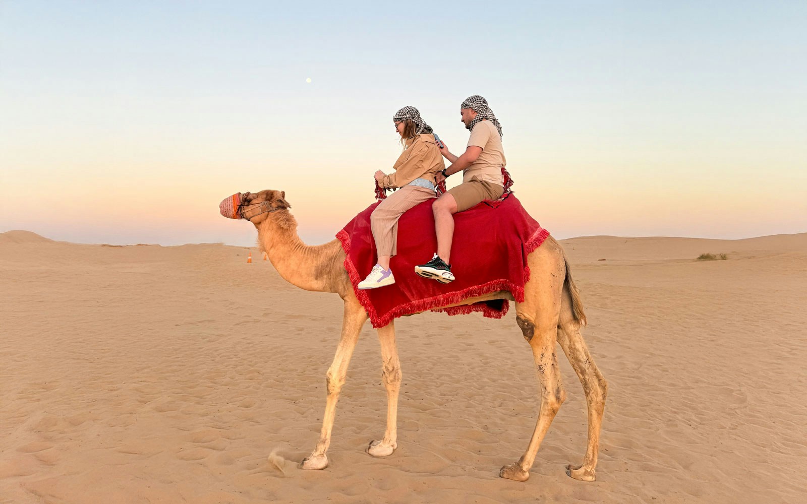 Camel ride during Dubai desert safari at sunset.