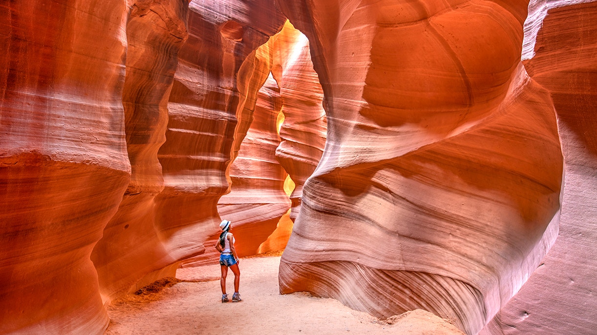 Tourist exploring the sunlit Upper Antelope Canyon in the US