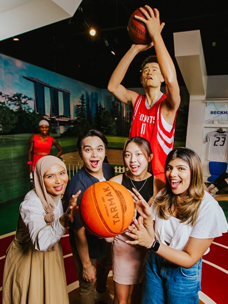 Visitors interacting with Yao Ming wax figure at Madame Tussauds Singapore.