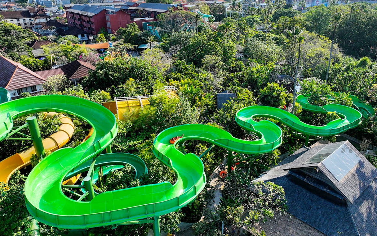Waterbom Bali green water slide winding through lush tropical landscape.