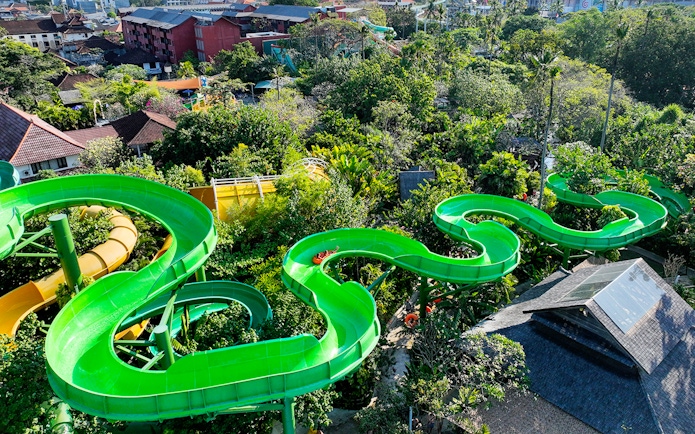 Waterbom Bali green water slide winding through lush tropical landscape.