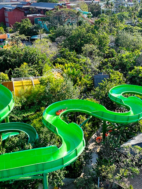 Waterbom Bali green water slide winding through lush tropical landscape.