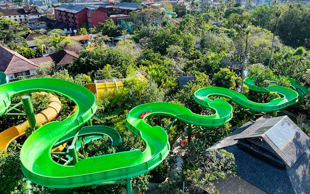 Waterbom Bali green water slide winding through lush tropical landscape.