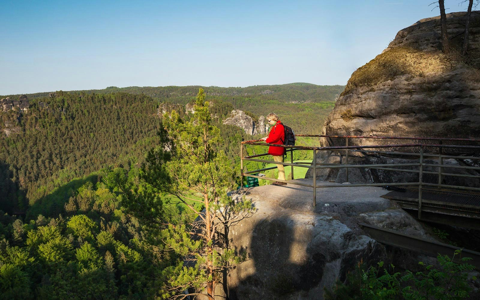 Visitor enjoying the view from a lookout in Saxon Switzerland National Park.