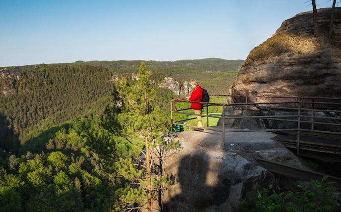 Visitor enjoying the view from a lookout in Saxon Switzerland National Park.