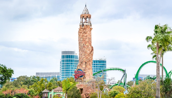 Islands of Adventure lighthouse at Universal Studios Resort, Orlando, with roller coaster in background.