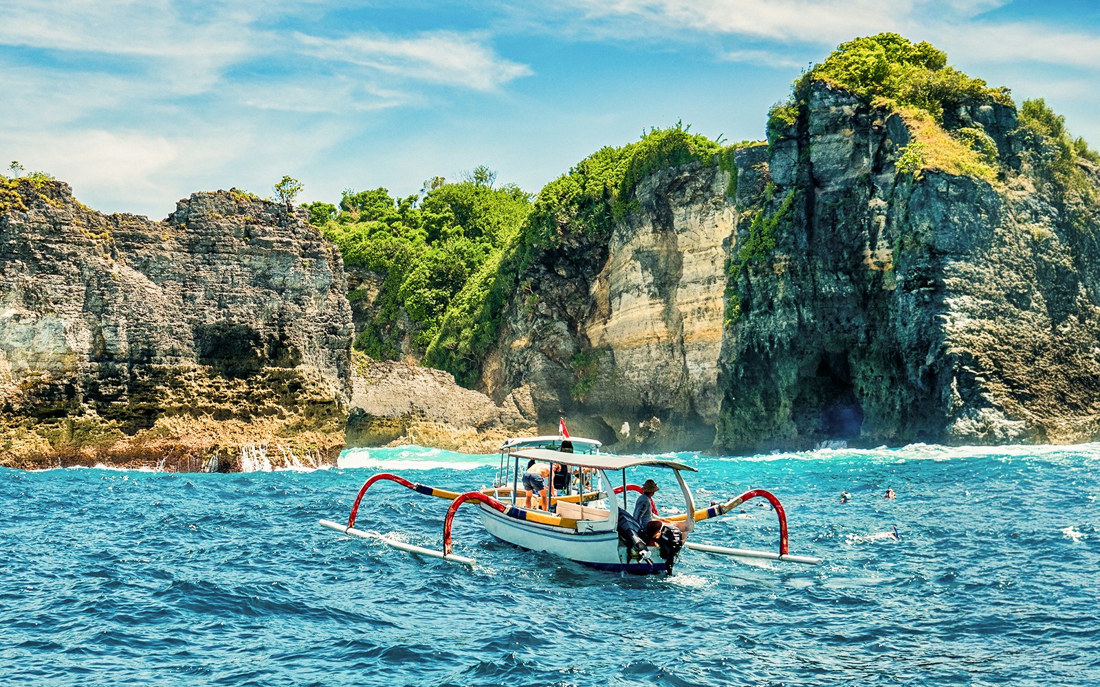 Boat near cliffs on West Nusa Penida Island during join-in tour.