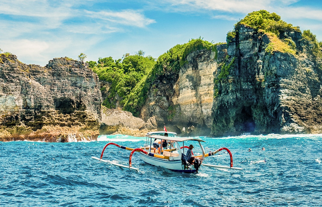 Group of tourists exploring the scenic beauty of West Nusa Penida Island, Indonesia, with convenient hotel transfers included in the tour package