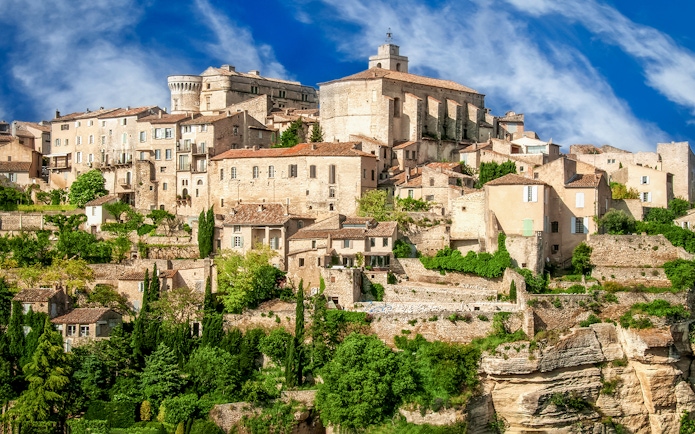 Hilltop village in Provence with stone buildings and lush greenery, part of Lavender Full Day Tour.