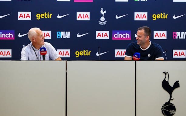 Two men at a press conference table with Tottenham Hotspur branding in the background.