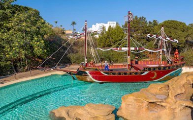 Pirate ship attraction at Terra Mitica Benidorm with surrounding greenery.