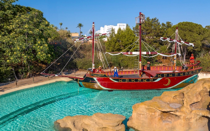 Pirate ship attraction at Terra Mitica Benidorm with surrounding greenery.