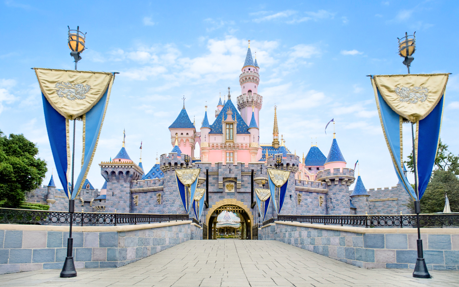 Disney Castle at Disneyland Park, California with blue and gold banners.