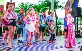 Guests participating in a dance at a traditional Hawaiian luau at Moana Luau, Hawaii.