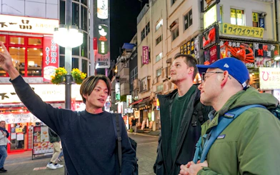Tour guide leading a group through Shinjuku's vibrant streets on a Tokyo Omakase Sushi & A5 Wagyu tour.