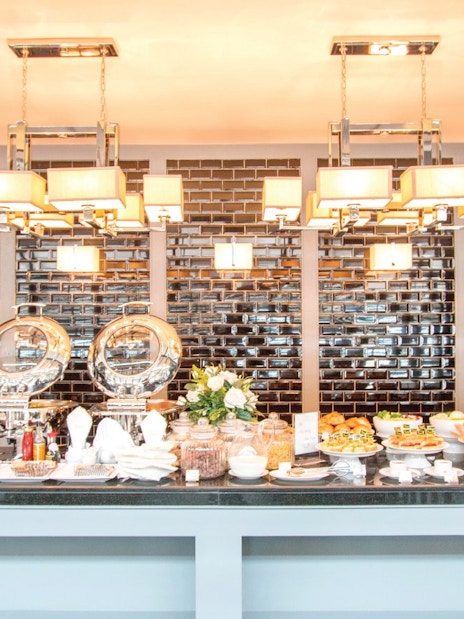 Buffet setup at The Coral Executive Lounge, Phuket International Airport, featuring snacks and beverages.