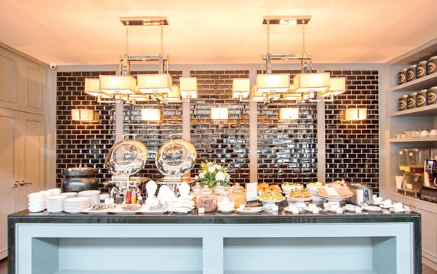 Buffet setup at The Coral Executive Lounge, Phuket International Airport, featuring snacks and beverages.