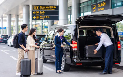 Group using Noi Bai Airport fast track service in Hanoi, with staff assisting luggage into a van.