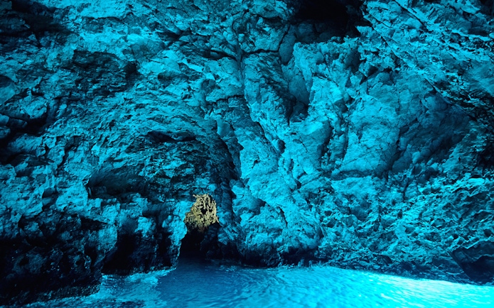 Blue cave interior with illuminated rock walls, Bisevo Island, Croatia.
