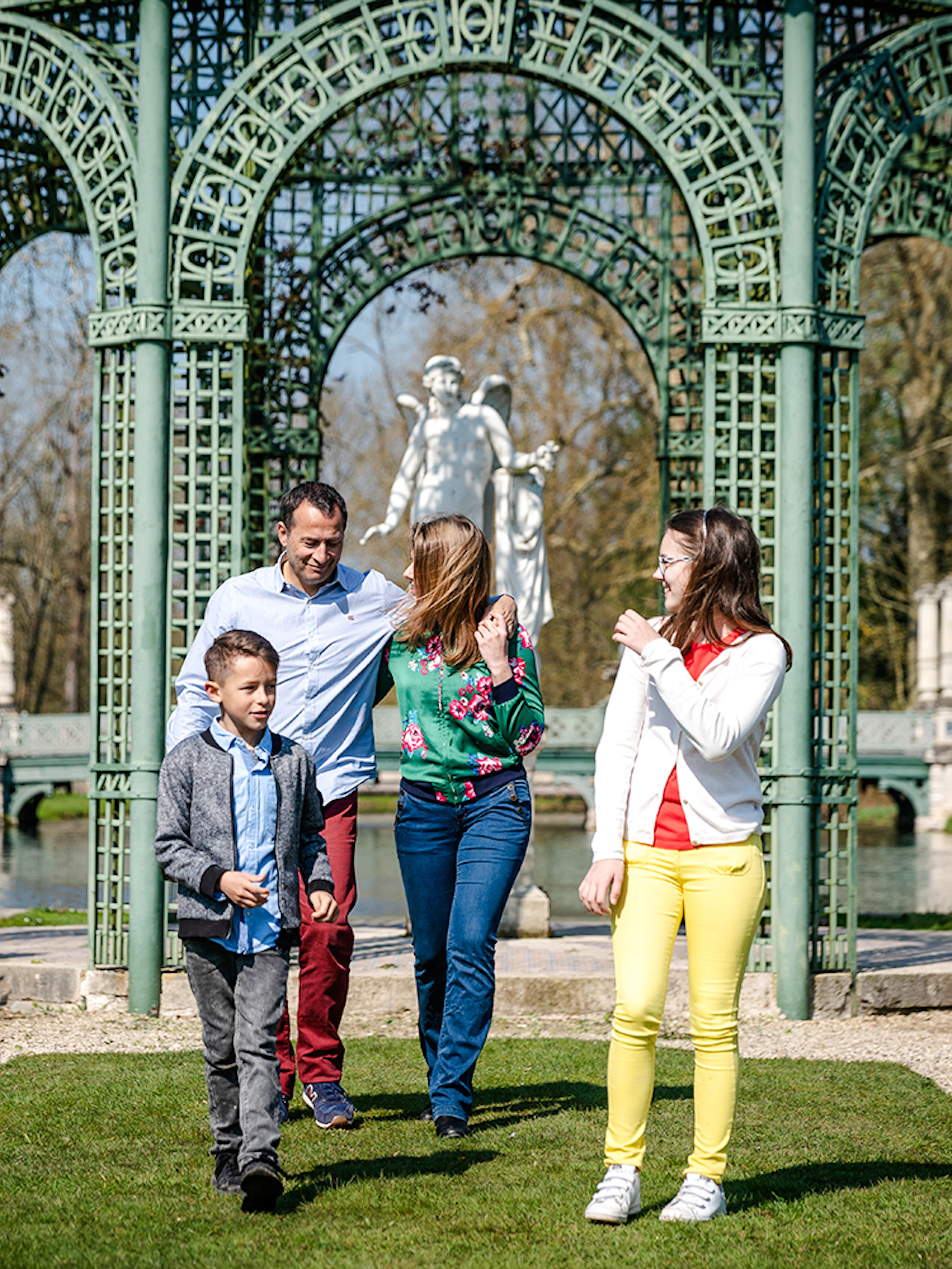 Family walking in the gardens of Chateau of Chantilly, France.