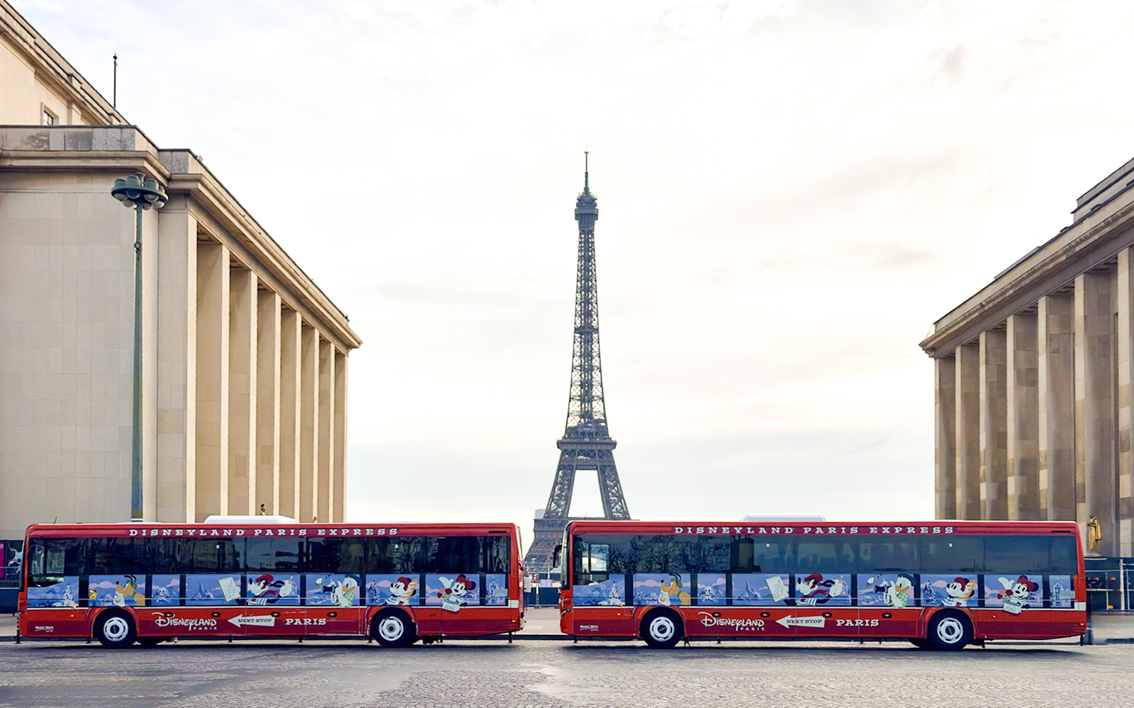 Disneyland Paris Express shuttle buses with Eiffel Tower in background.