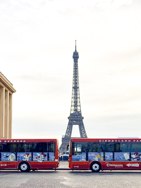 Disneyland Paris Express shuttle buses with Eiffel Tower in background.