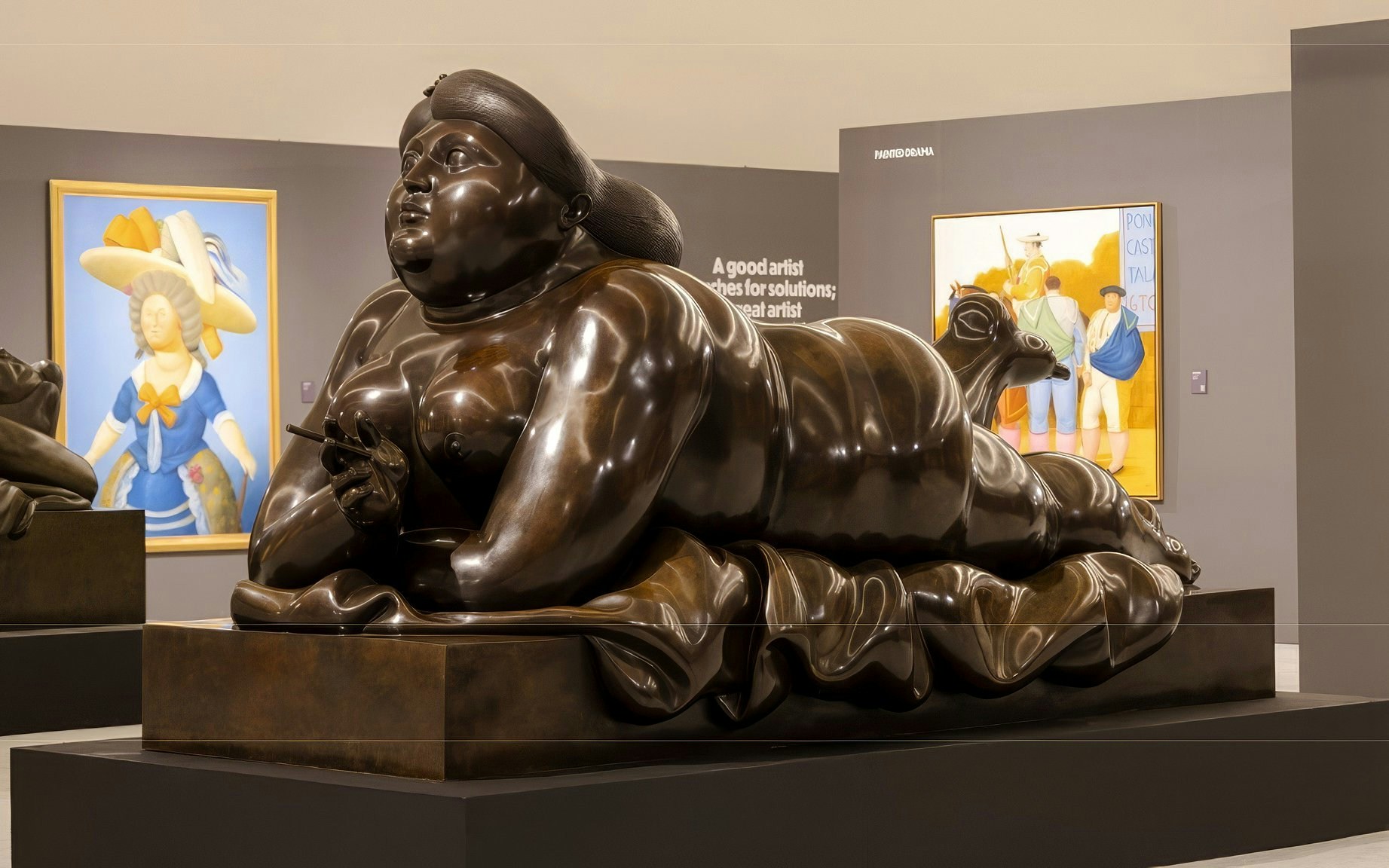 Sculpture of a reclining figure in Boterismo style at an art gallery.