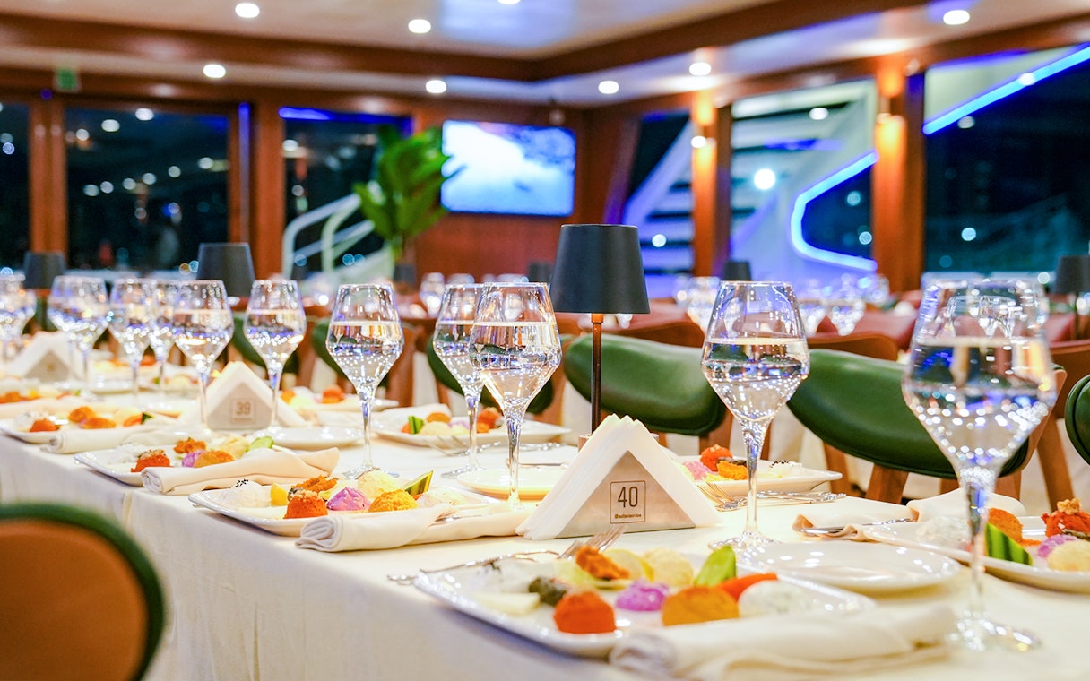 Dinner table set with wine glasses and colorful dishes on Bosphorus 4-Course Dinner Cruise.