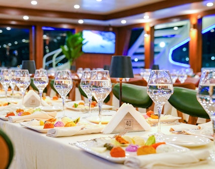 Dinner table set with wine glasses and colorful dishes on Bosphorus 4-Course Dinner Cruise.