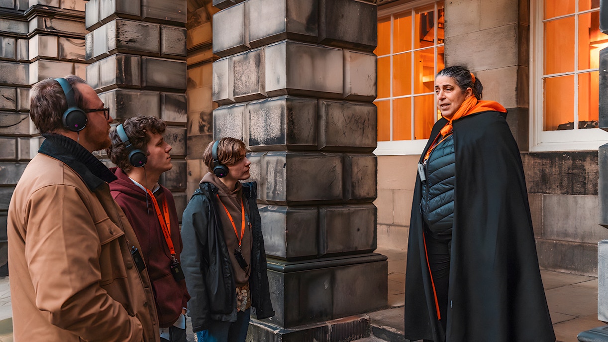 Tour guide with audio equipment leading a group on an underground tour in Edinburgh.