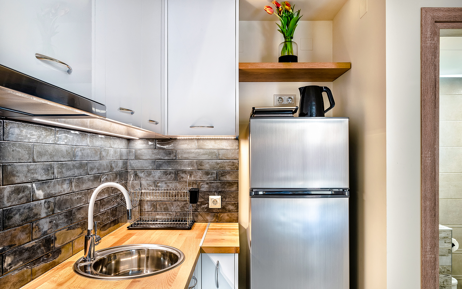 Modern hotel kitchenette with appliances and dining area in New York City.