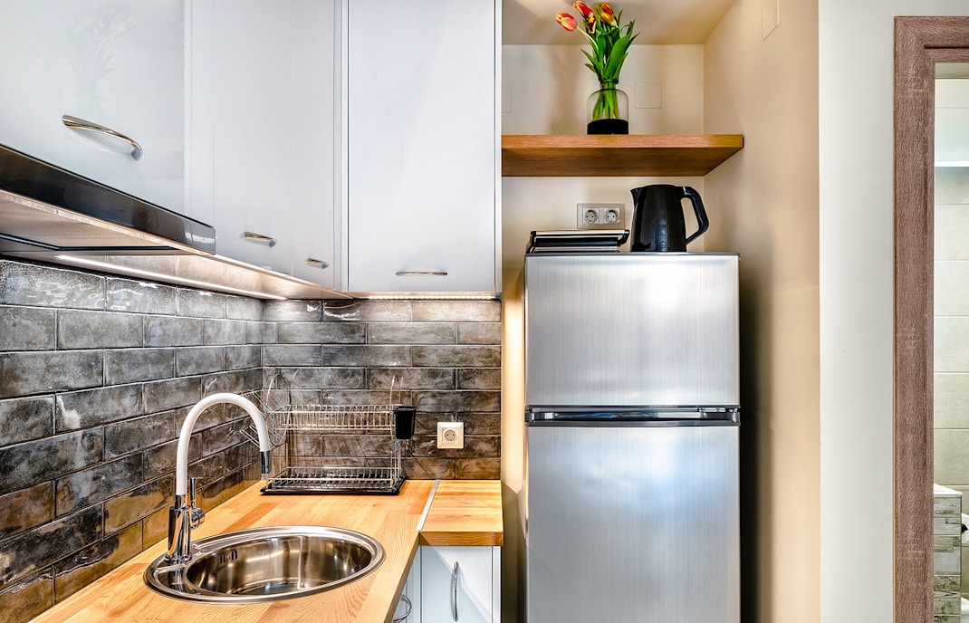 Modern hotel kitchenette with appliances and dining area