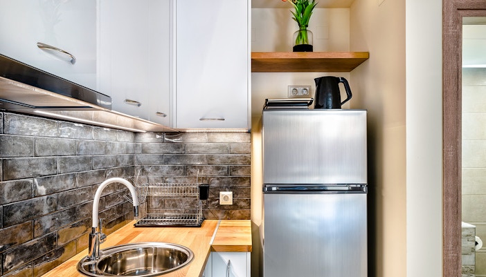 Modern hotel kitchenette with appliances and dining area in New York City.