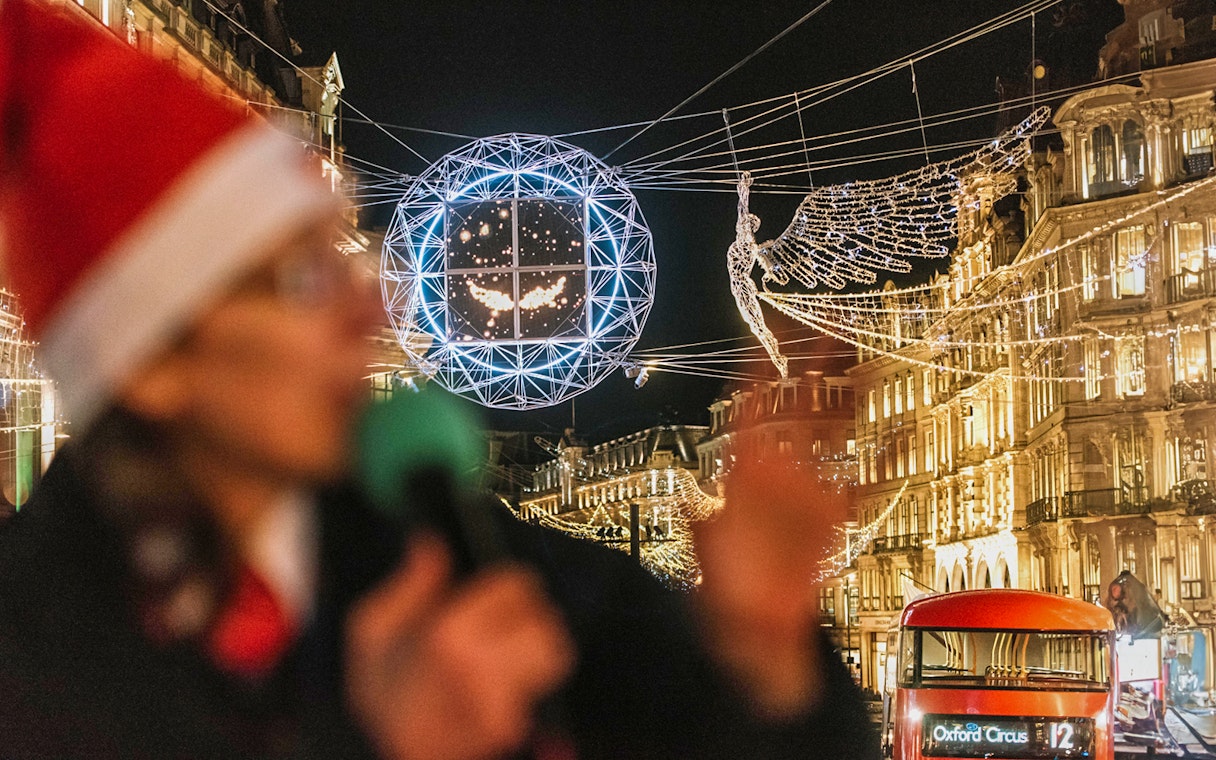 London Christmas lights and red bus on Tootbus tour at night.