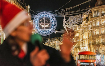 London Christmas lights and red bus on Tootbus tour at night.