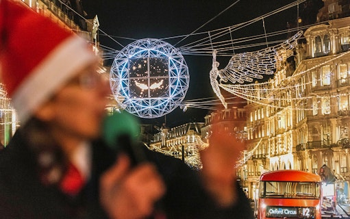London Christmas lights and red bus on Tootbus tour at night.