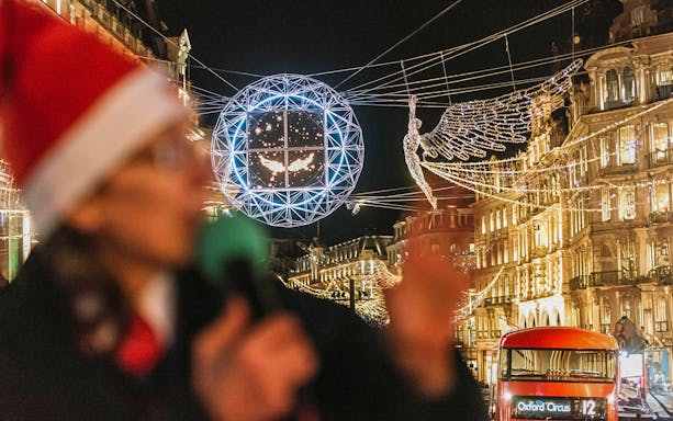 London Christmas lights and red bus on Tootbus tour at night.