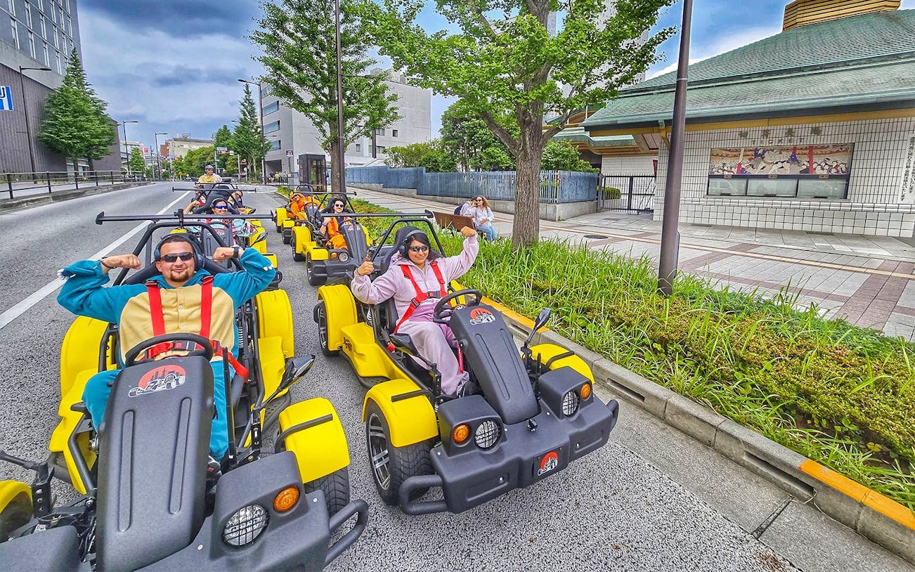 Group enjoying Uptown Go Kart Tour on city street with colorful karts.