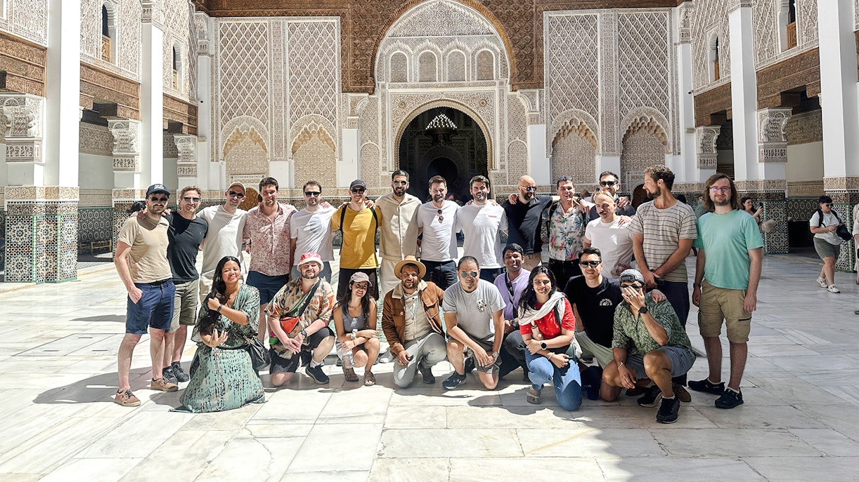 Group of tourists at Ben Youssef Madrasa courtyard in Marrakech, Morocco.
