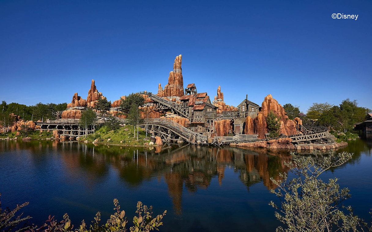 Big Thunder Mountain Railroad at Disneyland Paris with rocky landscape and water reflection.