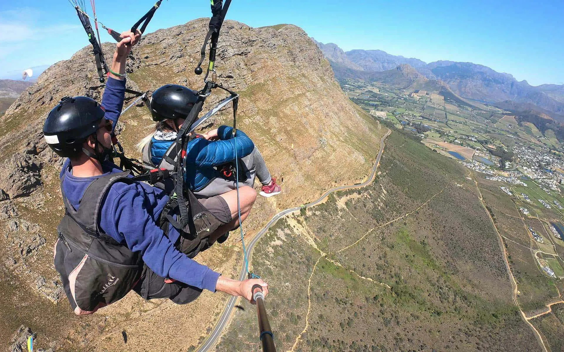 Tandem paragliding over mountains near Cape Town with scenic valley views.