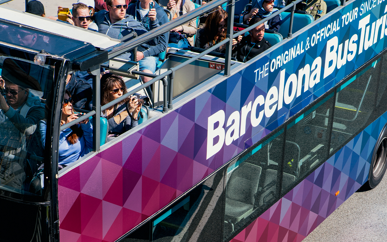 Tourists on an open-top bus during the Barcelona City Hop On Hop Off Tour.