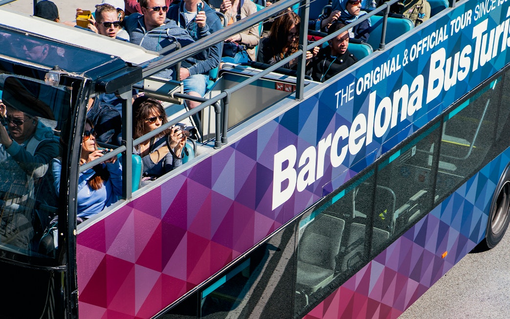 Tourists on an open-top bus during the Barcelona City Hop On Hop Off Tour.