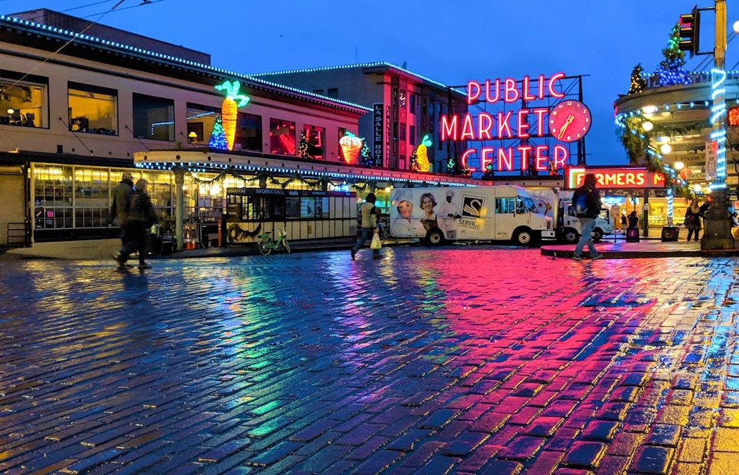 Seattle's Pike Place Market bustling with visitors and vendors displaying fresh produce and local goods.
