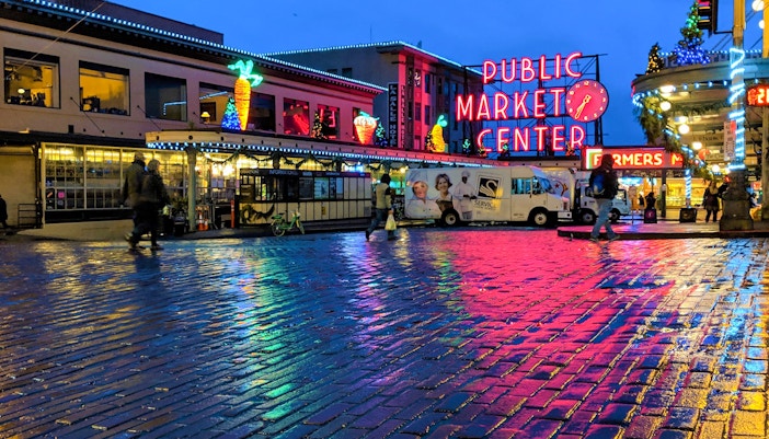 Seattle's Pike Place Market bustling with visitors and vendors displaying fresh produce and local goods.