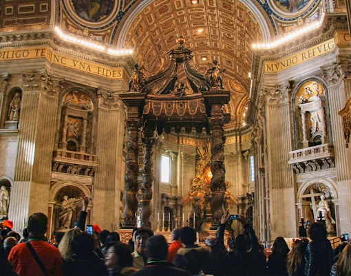 Interior view of St. Peter's Basilica dome and ornate ceiling in Vatican City.