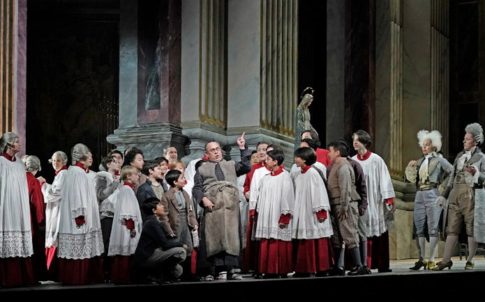 Opera performers in period costumes during a scene from Tosca.