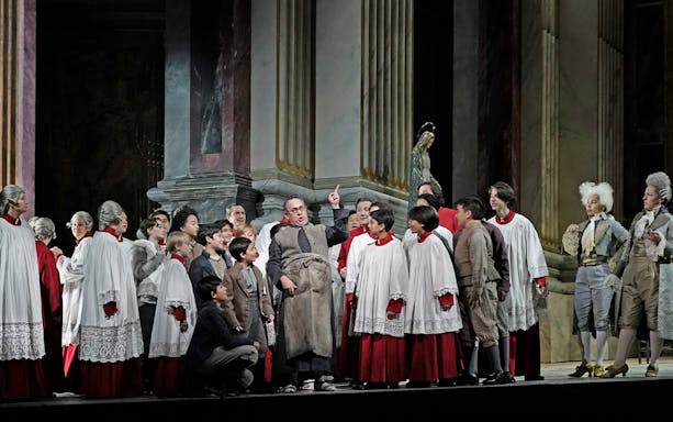 Opera performers in period costumes during a scene from Tosca.