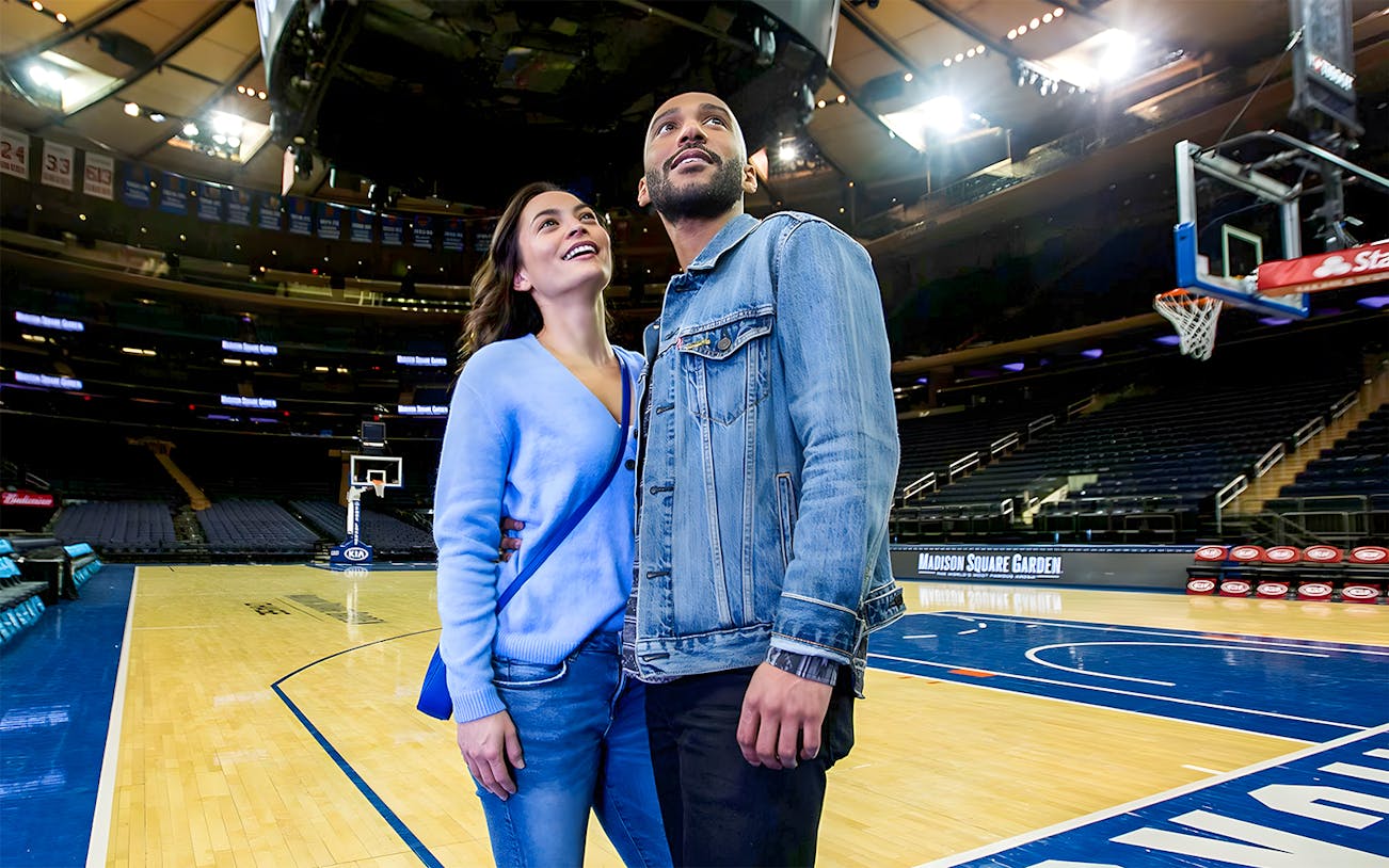 Couple exploring basketball court during Madison Square Garden guided tour.